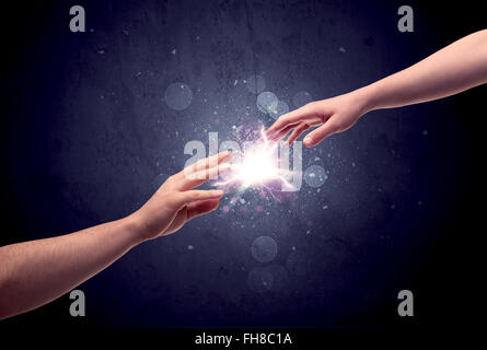 Hands reaching to light a spark Stock Photo