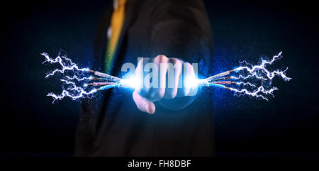 Business person holding electrical powered wires Stock Photo