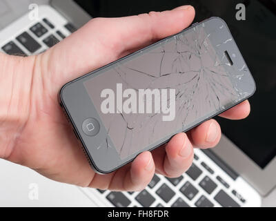 Los Angeles, CA, USA - December 07, 2015: Man holds in his hand broken Apple iPhone with cracked screen Stock Photo