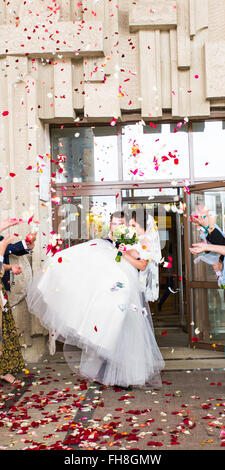 Guests Throwing Confetti Over Bride And Groom At Wedding Stock Photo