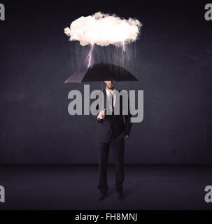 Businessman standing with umbrella and little storm cloud Stock Photo