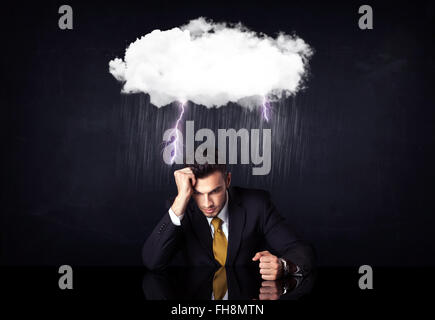 Depressed businessman sitting under a cloud Stock Photo