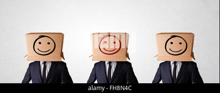 Handsome men in suit gesturing with drawn smiley faces on box Stock Photo