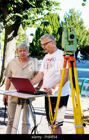 Land surveyors taking measures with Leica TCR 307 theodolite and laptop computer Stock Photo