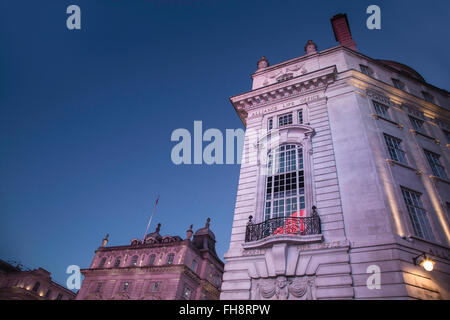 Twilight in Piccadilly Circus with Bright Lights from Iconic Signage Brightening Old Buildings Stock Photo