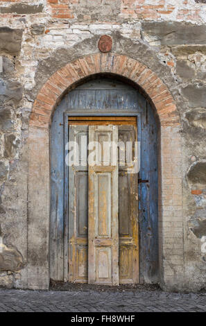 Grungy old locked door painted with yellow and blue paint. Amazing medieval time. Stock Photo