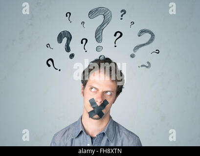 Young man with glued mouth and question mark symbols Stock Photo