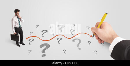 Business man looking at question marks and solution path Stock Photo
