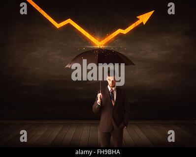 Businessman standing with umbrella keeping orange arrow Stock Photo