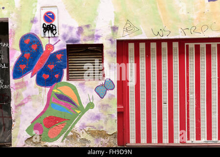 Red and white garage door with painted graffiti butterflies in Bilbao, Spain Stock Photo