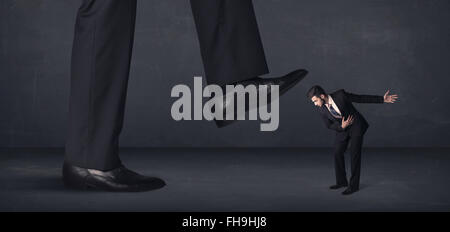 Giant person stepping on a little businessman concept Stock Photo