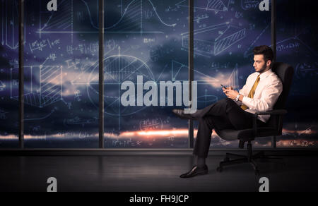 Businessman holding tablet in office room with graph charts on window Stock Photo