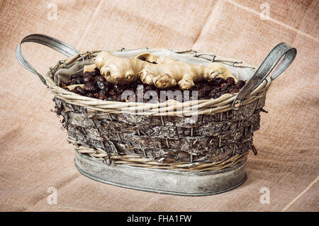 Dried rosehips and ginger arranged in the wicker tin basket. Healthy lifestyle. Still life. Stock Photo