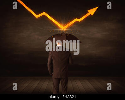 Businessman standing with umbrella keeping orange arrow Stock Photo