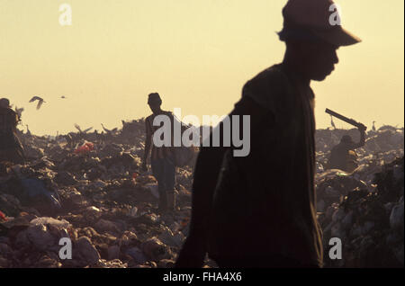 Pickers sort through garbage finding recyclables as a means of survival at Metropolitan Landfill of Jardim Gramacho (  Aterro Metropolitano de Jardim Gramacho ) in Duque de Caxias city, one of the largest landfills in the world, closed in June 2012 after 34 years of operation when it received most of the garbage produced in Rio de Janeiro city - it was started on an ecologically-sensitive wetland in the 1970s adjacent to Guanabara Bay. Stock Photo