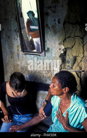 Family Doctor Program ( Programa Medico de Familia ) supported by the Brazilian Government - poor families from countryside Brazil receive healthcare and family medicine at home, based on knowledge of the patient in the context of the family and the community, emphasizing disease prevention and health promotion. Nurse measures elderly woman´s blood pressure, Rural area of Palmares city, Pernambuco State, Brazil. Stock Photo