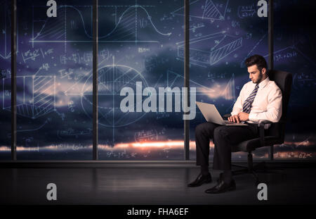 Businessman holding laptop in office room with graph charts on window Stock Photo