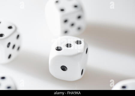 Several white dices with black eyes on a white table Stock Photo
