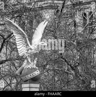 Statue of golden eagle with talons grasping ball with Ministry of Defence building in back ground Stock Photo