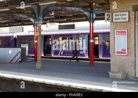 Northern Rail Electric train carrying the Northern Electrics brand at Warrington Bank Quay with a passenger about to join Stock Photo