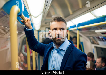 Serious businessman travelling to work. Standing inside undergro Stock Photo