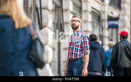 Hipster man with eyeglasses shopping in streets of London Stock Photo
