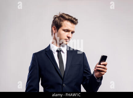 Hipster businessman with smartphone writing text message. Studio Stock Photo