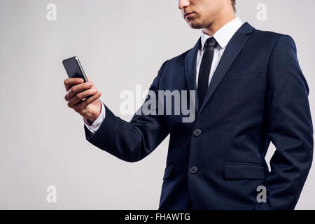 Hipster businessman with smartphone writing text message. Studio Stock Photo