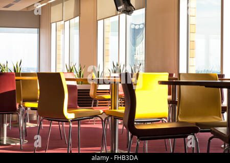 Colorful leather chairs and tables in a modern café, with big windows Stock Photo