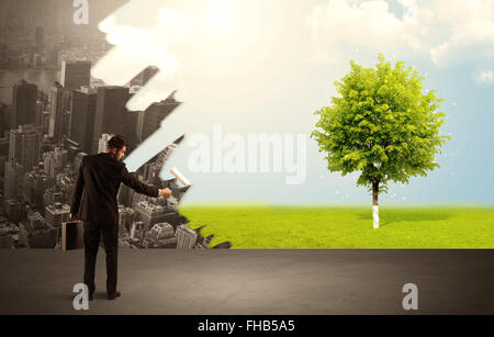 Salesman painting tree instead of city Stock Photo - Alamy