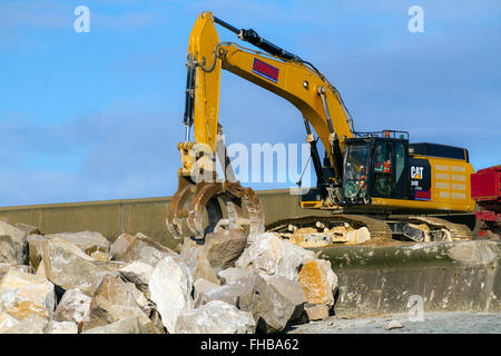 Blackpool, Fleetwood, Lancashire, UK. 24th February, 2016. Rossall Coastal defence £86million project resumes.  After recent storms and high winds, rock placement continues on the revetment at the southern end of the works with an additional 9,500 tonnes of primary rock placed. Primary rock placement now totals 95,000 tonnes and 171,500 tonnes of it have now been delivered to site.  Cernan Elias/Alamy Live News Stock Photo