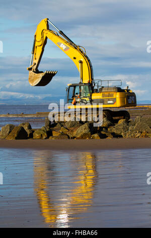 Blackpool, Fleetwood, Lancashire, UK. 24th February, 2016. Rossall Coastal defence £86million project resumes.  After recent storms and high winds, rock placement continues on the revetment at the southern end of the works with an additional 9,500 tonnes of primary rock placed. Primary rock placement now totals 95,000 tonnes and 171,500 tonnes of it have now been delivered to site.  Cernan Elias/Alamy Live News Stock Photo