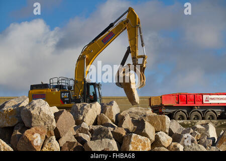 Blackpool, Fleetwood, Lancashire, UK. 24th February, 2016. Rossall Coastal defence £86million project resumes.  After recent storms and high winds, rock placement continues on the revetment at the southern end of the works with an additional 9,500 tonnes of primary rock placed. Primary rock placement now totals 95,000 tonnes and 171,500 tonnes of it have now been delivered to site.  Cernan Elias/Alamy Live News Stock Photo