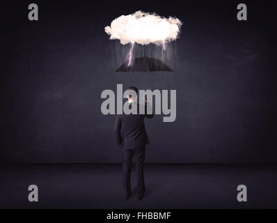 Businessman standing with umbrella and little storm cloud Stock Photo