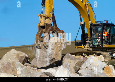 Blackpool, Fleetwood, Lancashire, UK. 24th February, 2016. Rossall Coastal defence £86million project resumes.  After recent storms and high winds, rock placement continues on the revetment at the southern end of the works with an additional 9,500 tonnes of primary rock placed. Primary rock placement now totals 95,000 tonnes and 171,500 tonnes of it have now been delivered to site.  Cernan Elias/Alamy Live News Stock Photo