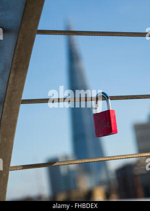 Love padlocks attached to the Millennium Bridge symbolising love with the Shard in the distance, City of London, England, UK, Eu Stock Photo