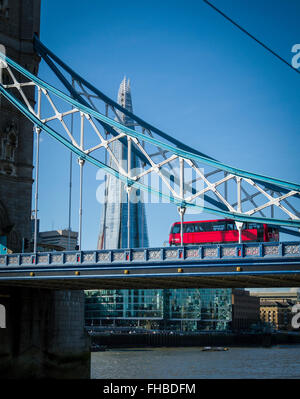 Red London double decker bus crosses Tower Bridge with The Shard in the distance, City of London, England, UK, Europe Stock Photo