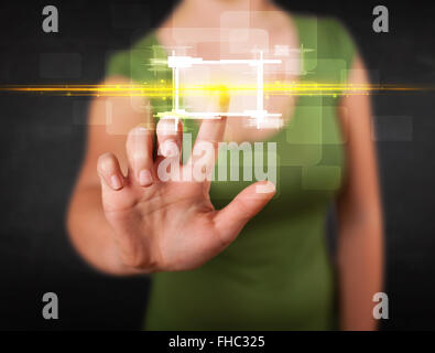 Young tech lady touching button with orange light beams concept Stock Photo