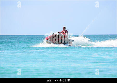 Young guy cruising on a jet ski on the caribbean sea Stock Photo