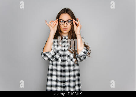 Portrait of cute teen girl wearing stylish shirt isolated on gray background fashion for teenagers in a photostudio Stock Photo