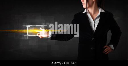 Young tech lady touching button with orange light beams concept Stock Photo