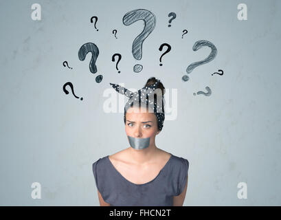 Young woman with glued mouth and question mark symbols Stock Photo