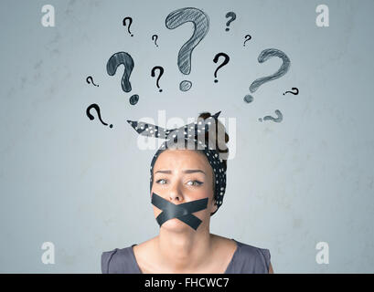 Young woman with glued mouth and question mark symbols Stock Photo