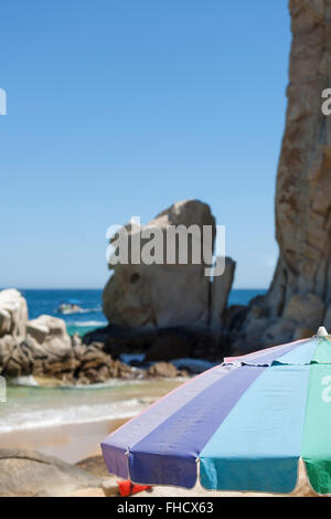 An Umbrella sits on a beach in Cabo San Lucas at Lands end. Stock Photo