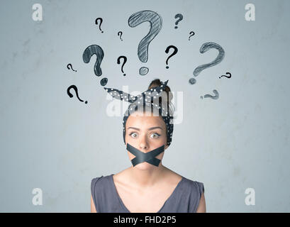 Young woman with glued mouth and question mark symbols Stock Photo