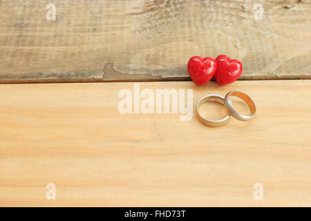 A ring with a red heart on a wood floor, Brown. Stock Photo