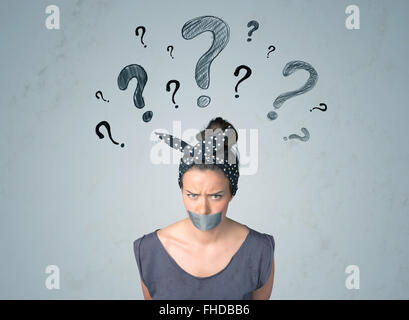 Young woman with glued mouth and question mark symbols Stock Photo