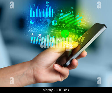 Hand holding smartphone with business diagrams Stock Photo