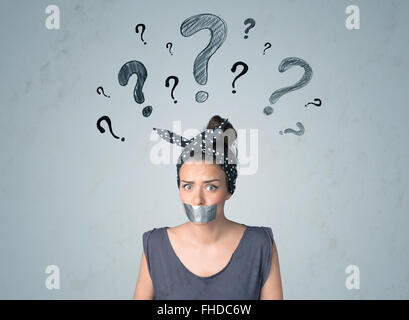 Young woman with glued mouth and question mark symbols Stock Photo