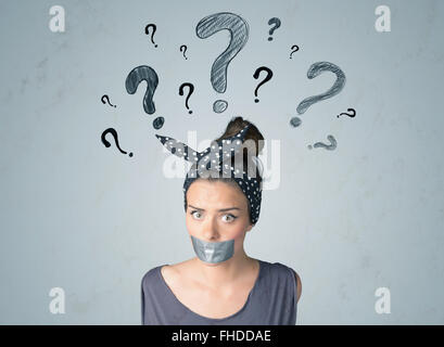 Young woman with glued mouth and question mark symbols Stock Photo